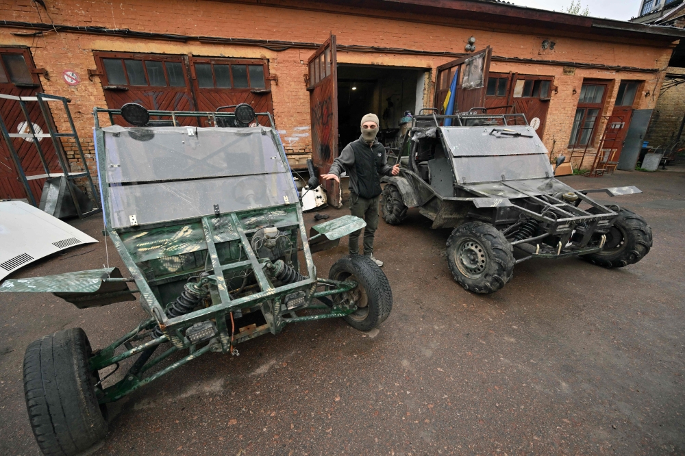 29 year-old Musa talks as he stands next buggies outside Dracary's workshop at an industrial site in Ukrainian capital of Kyiv on April 27, 2023. (Photo by Sergei Supinsky / AFP)