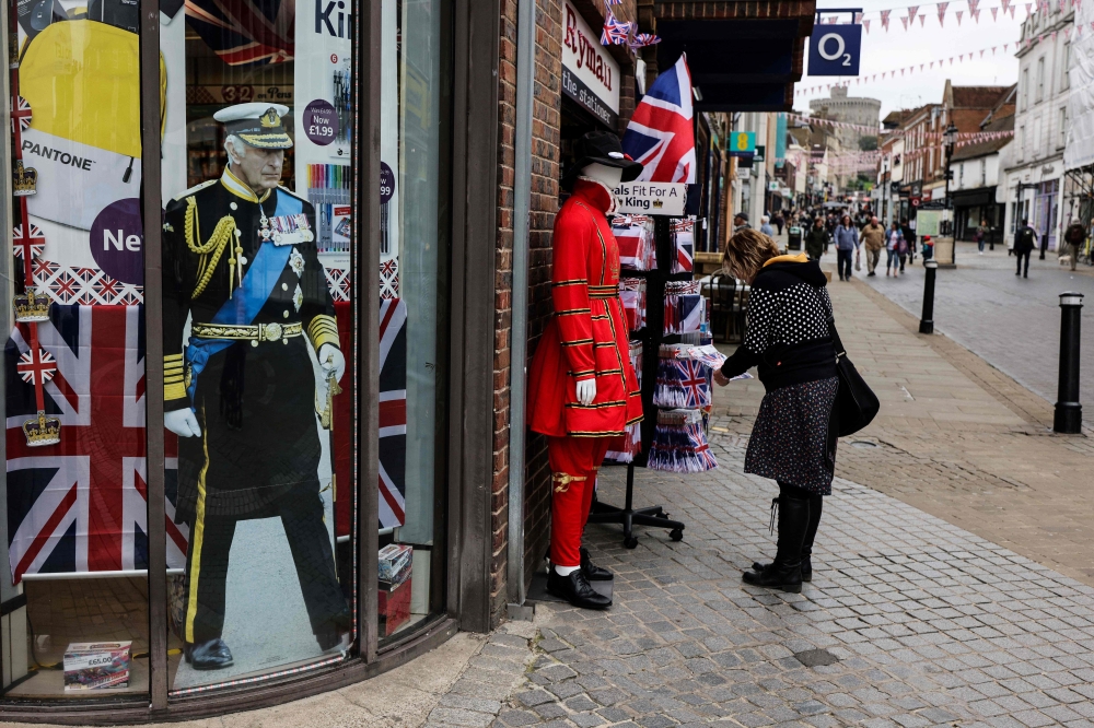 A woman looks at a merchandise shop selling royals souvenirs, in Windsor, on May 2, 2023, ahead of the coronation ceremony of Charles III and his wife, Camilla, as King and Queen of the United Kingdom and Commonwealth Realm nations, on May 6, 2023. Photo by Adrian DENNIS / AFP
