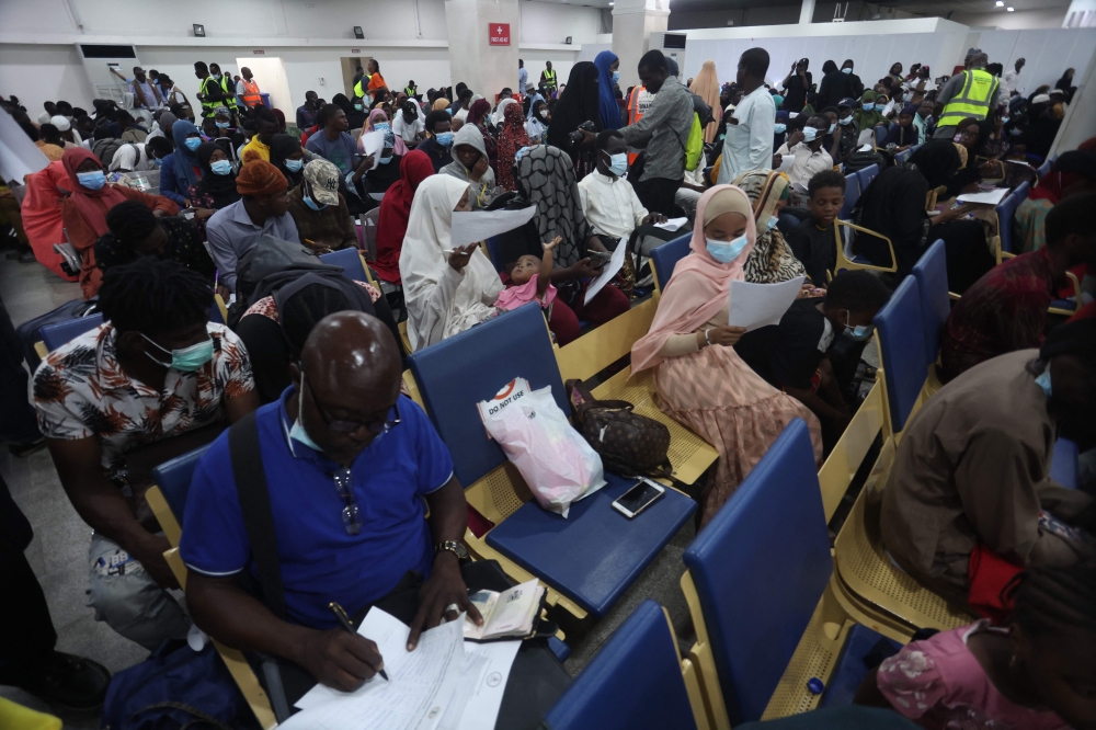 A view of fleeing Nigerian students in Sudan filling their arrival form after being evacuated from Sudan to Nigeria at the Nnamdi Azikwe International Airport in Abuja, Nigeria on May 4, 2023. (Photo by KOLA SULAIMON / AFP)