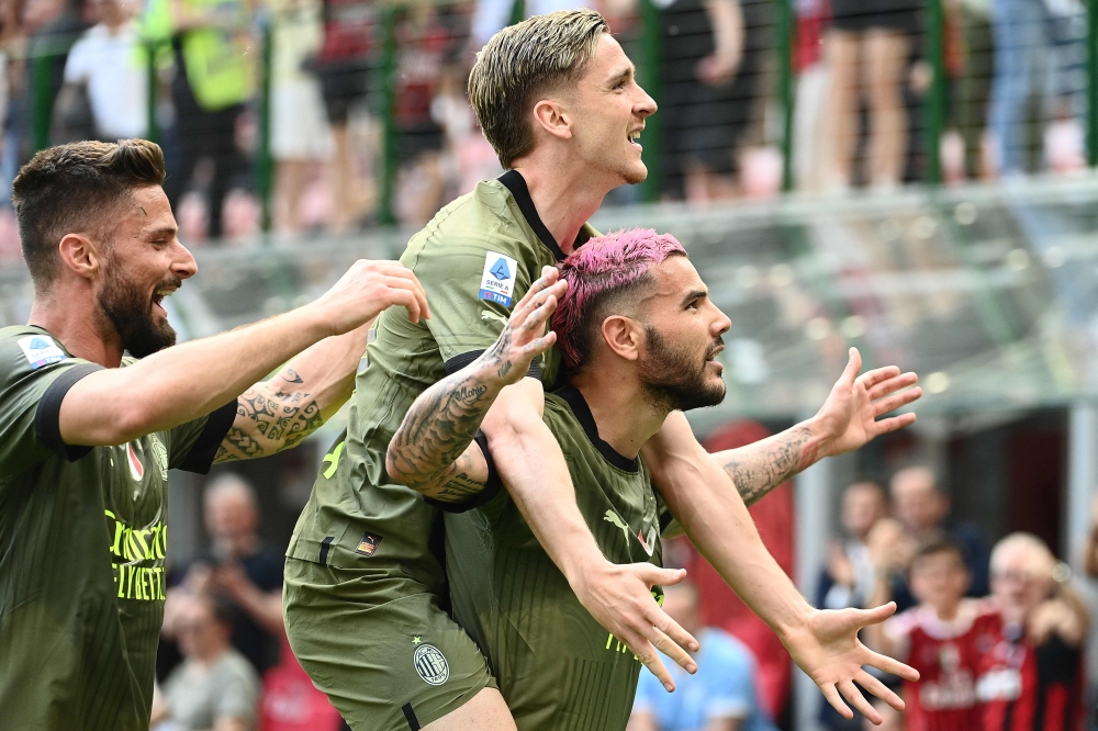AC Milan's French defender Theo Hernandez (R) celebrates with AC Milan's Belgian forward Alexis Saelemaekers (C) and AC Milan's French forward Olivier Giroud after scoring his side's second goal during the Italian Serie A football match between AC Milan and Lazio on May 6, 2023 at the San Siro stadium in Milan. (Photo by Isabella BONOTTO / AFP)
