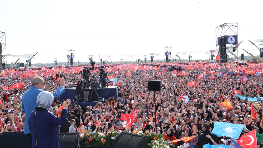 Turkish President and People's Alliance's presidential candidate Recep Tayyip Erdogan (left) and his wife Emine Erdogan wave to supporters during an election campaign rally in Istanbul, on May 7, 2023. (Photo by DHA (Demiroren News Agency) / AFP) 