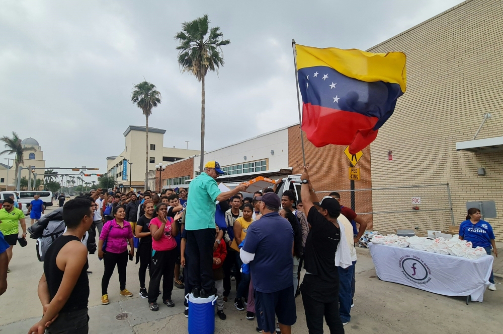 A group of Venezuelan migrants receive food and assistance from a local church in downtown Brownsville, Texas, on May 6, 2023. (Photo by Moisés VILA / AFP)
