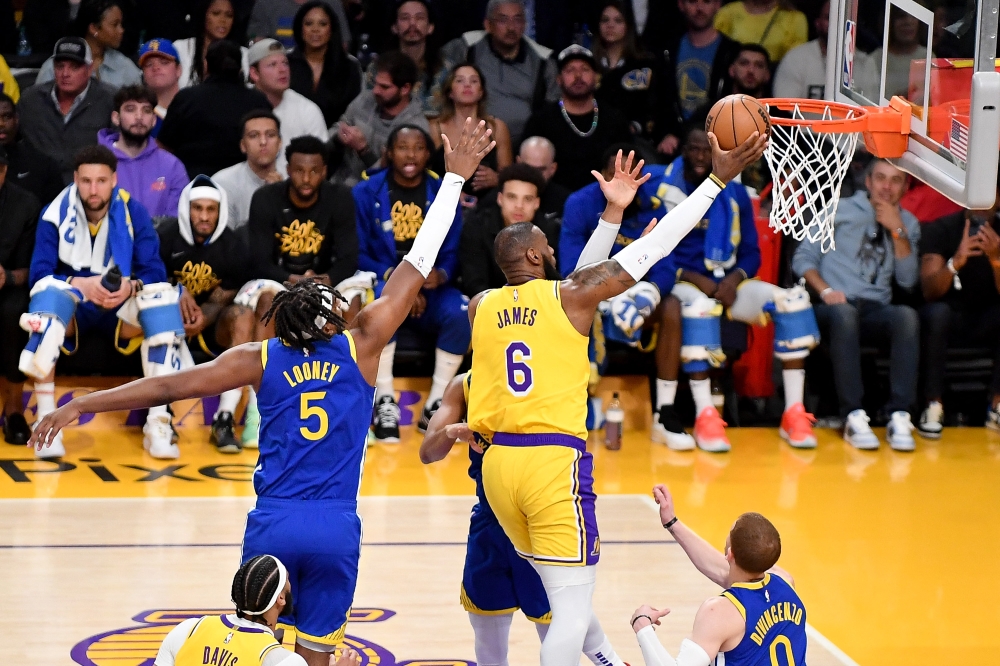 LeBron James #6 of the Los Angeles Lakers makes a layup against Kevon Looney #5 of the Golden State Warriors during Game Four of the Western Conference Semi-Finals of the 2023 NBA Playoffs at Crypto.com Arena on May 08, 2023 in Los Angeles, California.Photo by Allen Berezovsky /  AFP