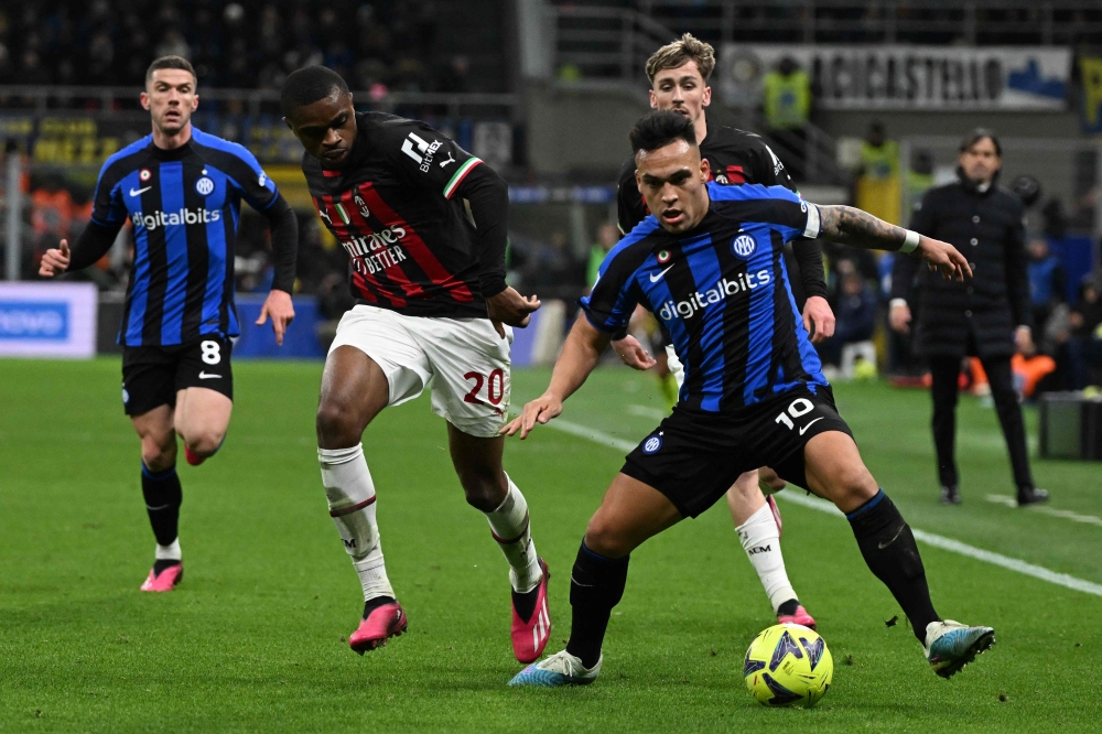 (FILES) In this file photo taken on February 05, 2023 Inter Milan's Argentinian forward Lautaro Martinez (R) and AC Milan's French defender Pierre Kalulu (L) Photo by MIGUEL MEDINA / AFP