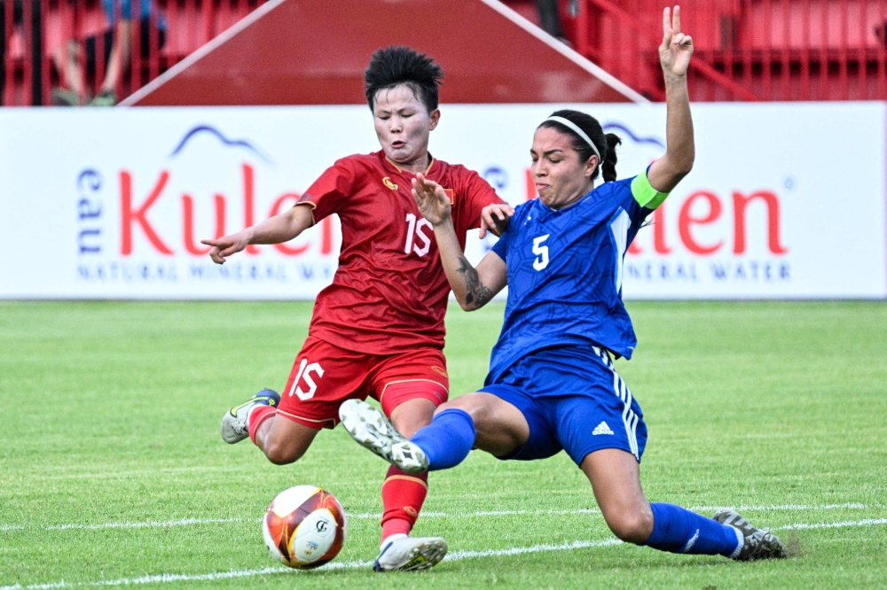 Vietnam's Nguyen Thi Bich Thuy (L) and Philippines' captain Hali Long (R) fight for the ball during the women's football match between Vietnam and Philippines at RSN Stadium during the 32nd Southeast Asian Games (SEA Games) in Phnom Penh on May 9, 2023. (Photo by NHAC NGUYEN / AFP)
