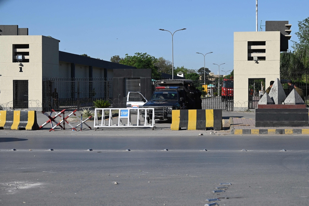 Policemen stand guard at the main entrance of the Pakistan's army headquaters in Rawalpindi on May 10, 2023. (Photo by Aamir Qureshi / AFP)