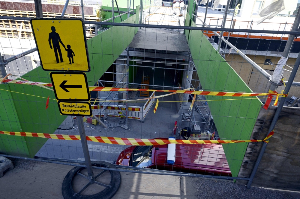 Barrier tape is fixed at the site of an accident in which around 27 people, a majority of them children, were injured on May 11, 2023 in Espoo, Finland, when a pedestrian bridge collapsed. (Photo by Jussi Nukari / Lehtikuva / AFP) 