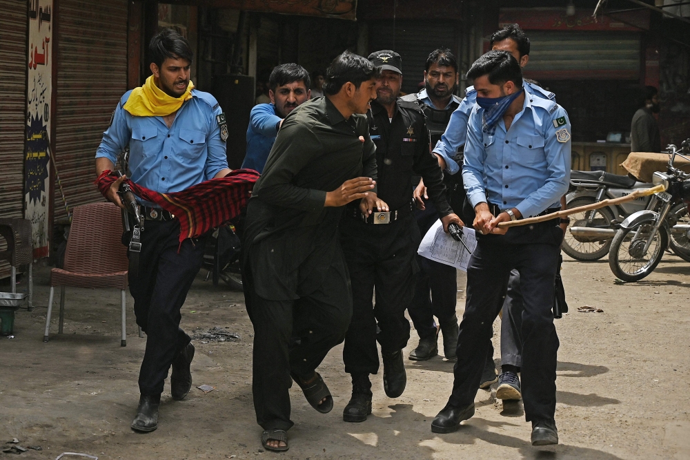 Policemen detain Pakistan Tehreek-e-Insaf (PTI) party activists and supporters of former Pakistan's Prime Minister Imran Khan during an ongoing protest against the arrest of their leader, in Islamabad on May 11, 2023. (Photo by Aamir Qureshi / AFP)