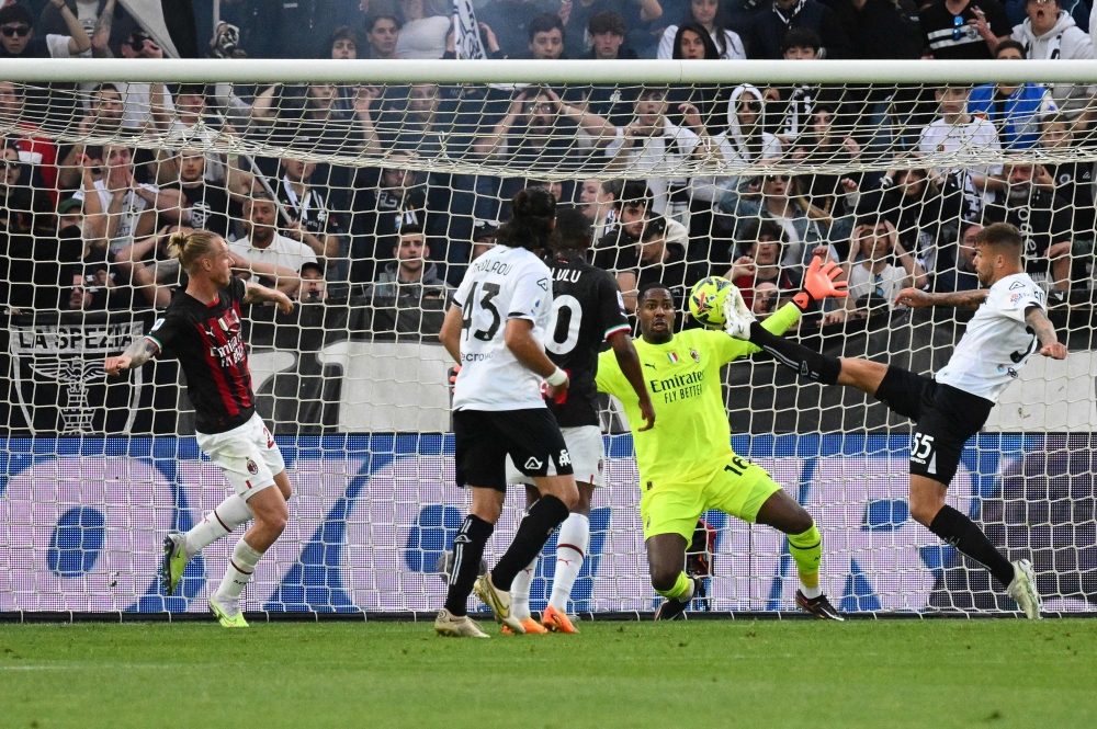 Spezia's Polish defender Przemyslaw Wisniewski (R) scores his team's first goal during the Italian Serie A football match between Spezia and AC Milan at the Alberto-Picco stadium in La Spezia, on May 13, 2023. (Photo by Vincenzo PINTO / AFP)
