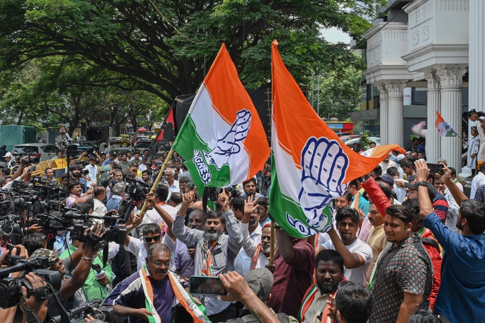 Congress supporters celebrate the party's victory in the Karnataka state legislative assembly election in Bengaluru on May 13, 2023. (Photo by Manjunath Kiran / AFP)