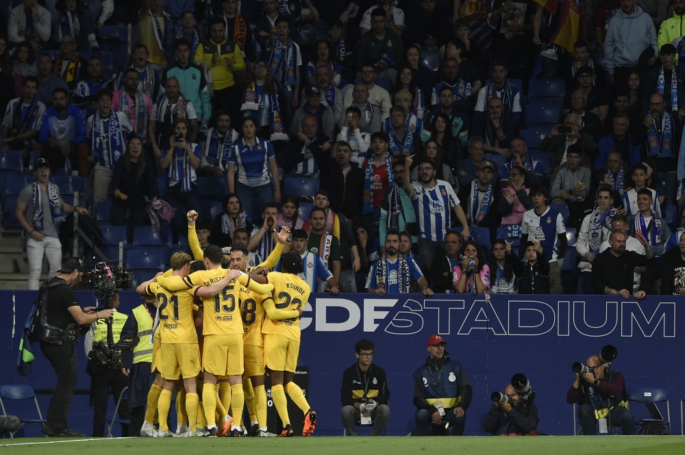 Barcelona's players celebrate their opening goal scored by Polish forward Robert Lewandowski celebrates scoring the opening goal during the Spanish league football match between RCD Espanyol and FC Barcelona at the RCDE Stadium in Cornella de Llobregat on May 14, 2023. (Photo by Josep LAGO / AFP)
