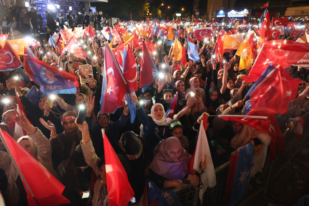 Supporters of Turkish President Tayyip Erdogan wave flags outside the AK Party headquarters after polls closed in Turkey's presidental and parliamentary elections in Ankara, Turkey. (Photo by Adem Altan / AFP)