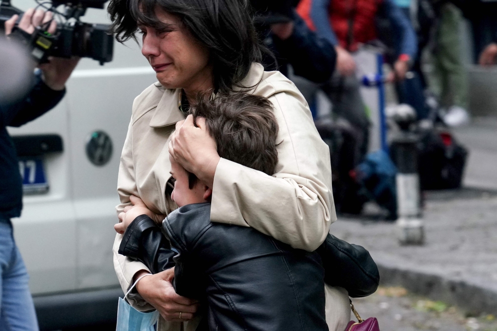 A parent escorts her child following a shooting at a school in the capital Belgrade on May 3, 2023. (Photo by Oliver Bunic / AFP)

