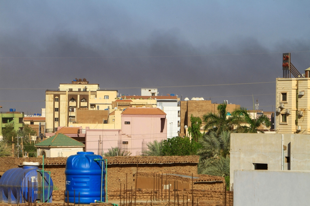 Smoke rises behind buildings in Khartoum amid ongoing fighting between the forces of two rival generals, on May 16, 2023. Photo by AFP
