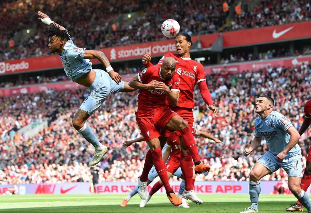 Aston Villa's English defender Tyrone Mings (L), Liverpool's Brazilian midfielder Fabinho (C) and Liverpool's Dutch defender Virgil van Dijk (2R) vie to header the ball during the English Premier League football match between Liverpool and Aston Villa at Anfield in Liverpool, north west England on May 20, 2023. (Photo by PETER POWELL / AFP) 