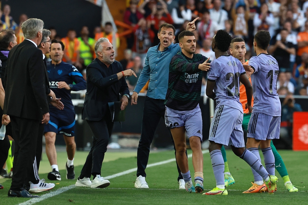 Real Madrid's Brazilian forward Vinicius Junior (3R) confronts a Valencia's official as he leaves after being sent off the pitch by the referee during the Spanish league football match between Valencia CF and Real Madrid CF at the Mestalla stadium in Valencia on May 21, 2023. (Photo by JOSE JORDAN / AFP)
