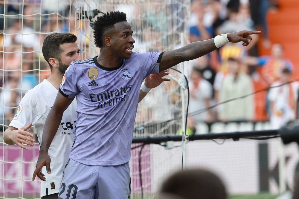 Real Madrid's Brazilian forward Vinicius Junior reacts to being insulted pointing at the stands during the Spanish league football match between Valencia CF and Real Madrid CF at the Mestalla stadium in Valencia on May 21, 2023. (Photo by Jose Jordan / AFP)
