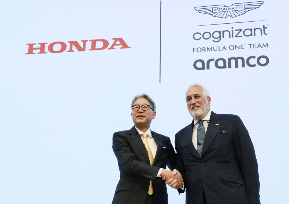 Honda Motor President Toshihiro Mibe (L) shakes hands with Aston Martin F1 executive chairman Lawrence Stroll during a press conference in Tokyo on May 24, 2023. Photo by JIJI Press / AFP