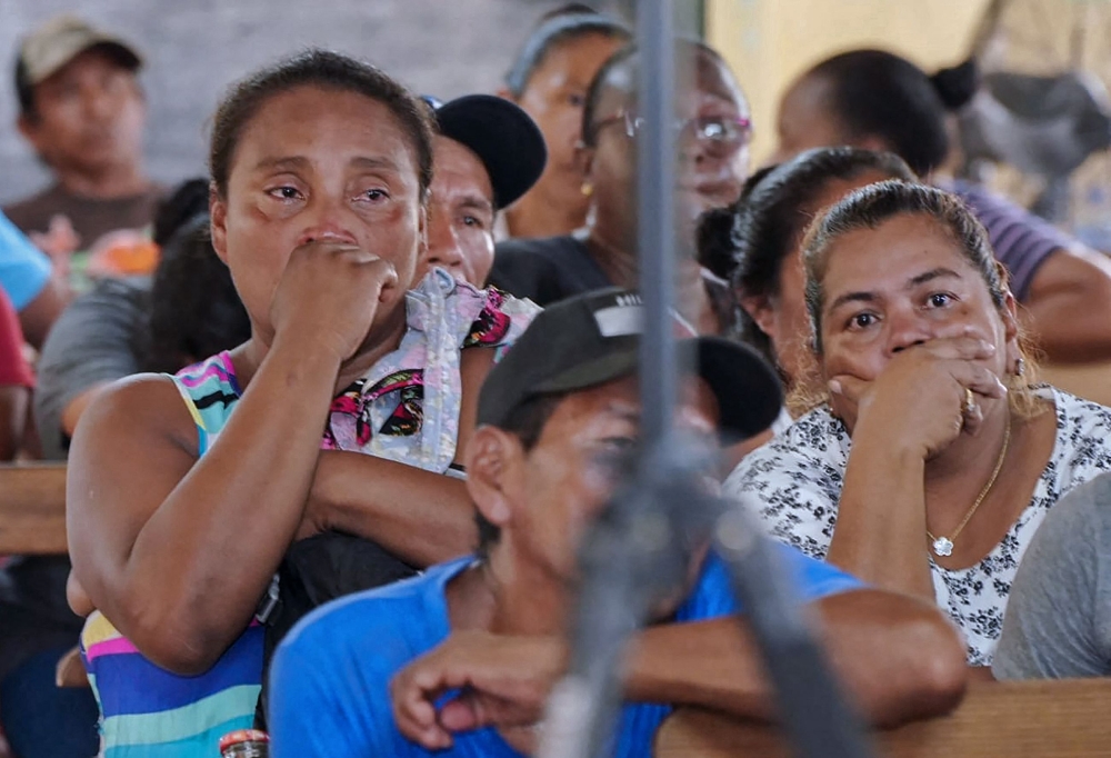 Relatives and friends of the victims of a fire on the eve that killed at least 19 youths and injured about 20 others in a schoolgirls' dormitory, cry during a meeting with Guyana's President Irfaan Ali, in Mahdia, Guyana. (Photo by Keno GEORGE / AFP)