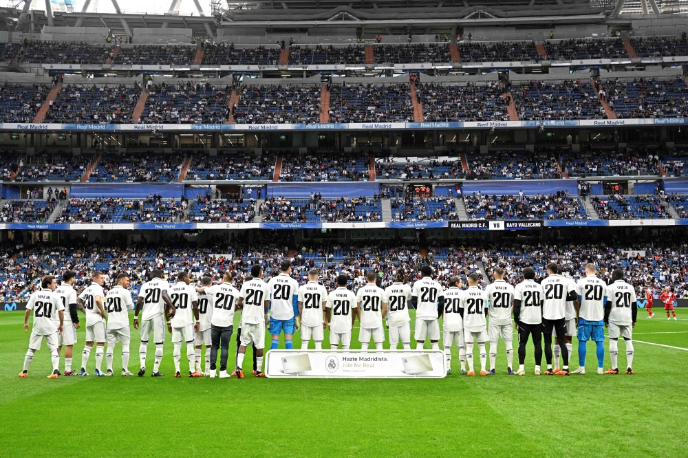 Real Madrid's players wear the jersey of Vinicius Junior in support to the Real Madrid's Brazilian forward prior the Spanish league football match between Real Madrid CF and Rayo Vallecano de Madrid at the Santiago Bernabeu stadium in Madrid on May 24, 2023. (Photo by JAVIER SORIANO / AFP)
