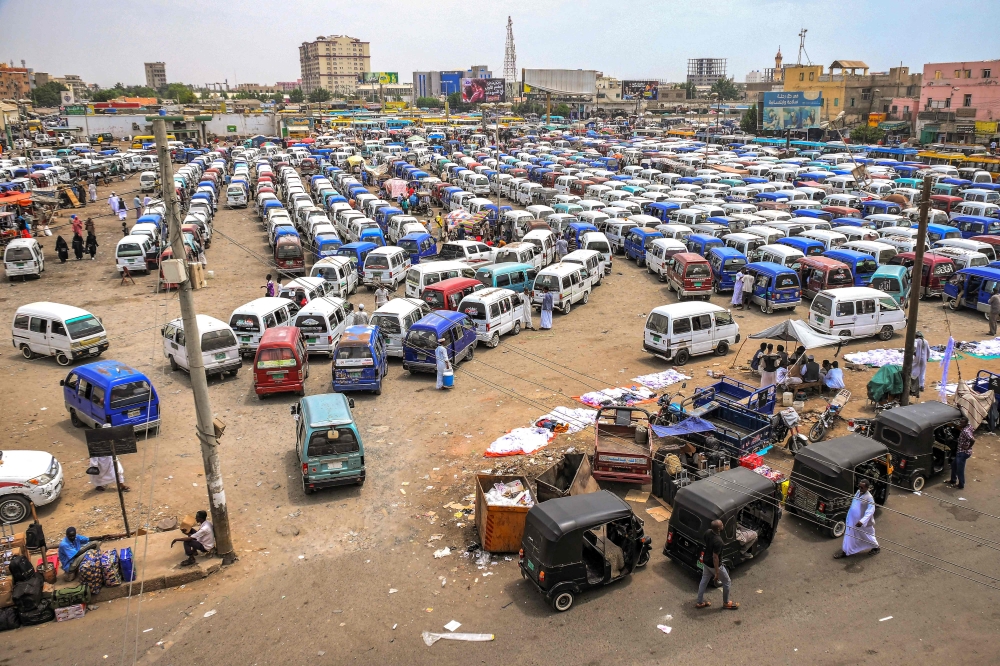 Minivan buses and tuk-tuks (motorised rickshaws) wait for passengers at a bus station in Port Sudan on May 23, 2023. (Photo by AFP)