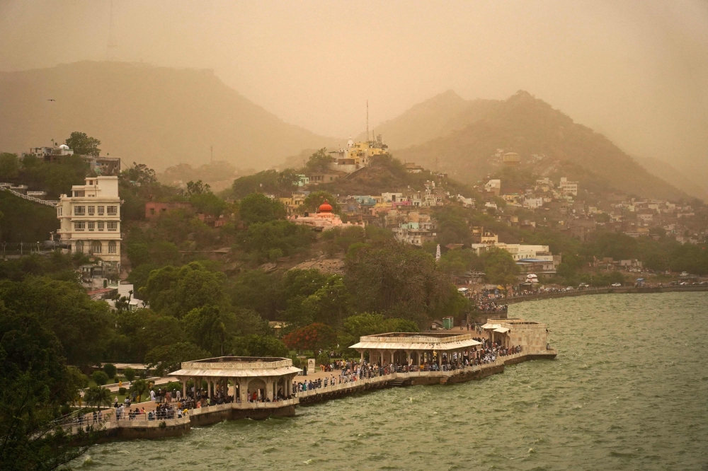 Tourists gather along the banks of Anasagar Lake during a duststorm in Ajmer on May 28, 2023. (Photo by Himanshu Sharma / AFP)