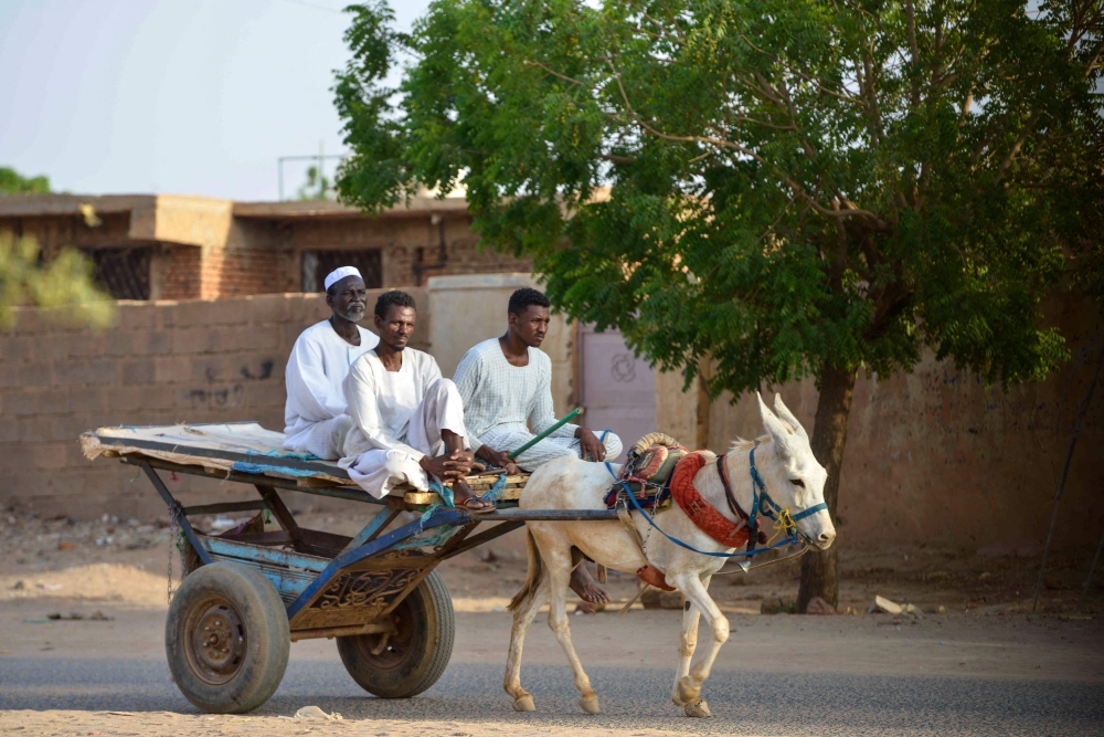 People ride a donkey-pulled cart along a street in Omdurman, Khartoum's twin city, on May 28, 2023, amid ongoing violence between the forces of two rival Sudanese generals. (Photo by AFP)