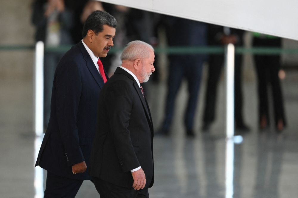 Venezuela's President Nicolas Maduro (L) walks with Brazilian President Luiz Inacio Lula da Silva during a welcome ceremony at Planalto Palace in Brasilia on May 29, 2023. (Photo by EVARISTO SA / AFP)

