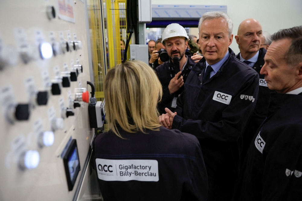 French Finance Minister Bruno Le Maire (C) visits the gigafactory of Automotive Cells Company (ACC), a joint venture of Stellantis, TotalEnergies and Mercedes, during its inauguration in Billy-Berclau-Douvrin, northern France, May 30, 2023. (Photo by Pascal Rossignol / POOL / AFP)