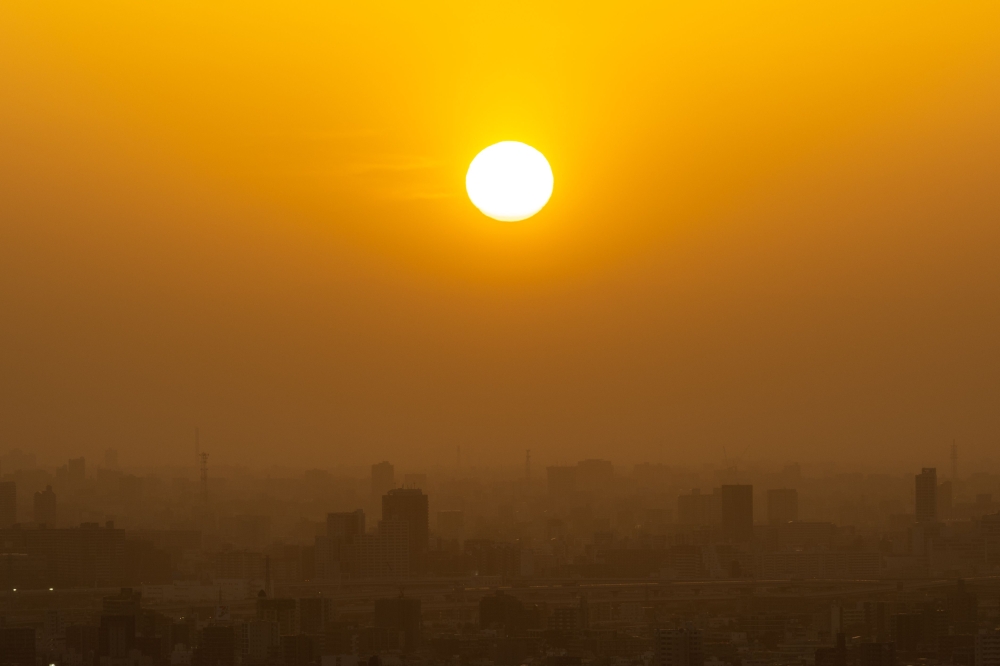 (Files) Tokyo's skyline is seen through the dusty air from the I-link Town observatory during the evening hour in Ichikawa city, Chiba prefecture, east of Tokyo on April 13, 2023. (Photo by Philip Fong / AFP)
 