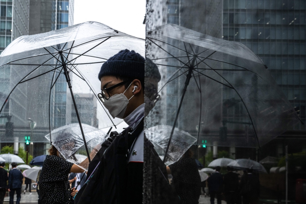 A man uses an umbrella to shelter from the rain at the Ginza district in Tokyo on June 2, 2023. Photo by Philip FONG / AFP