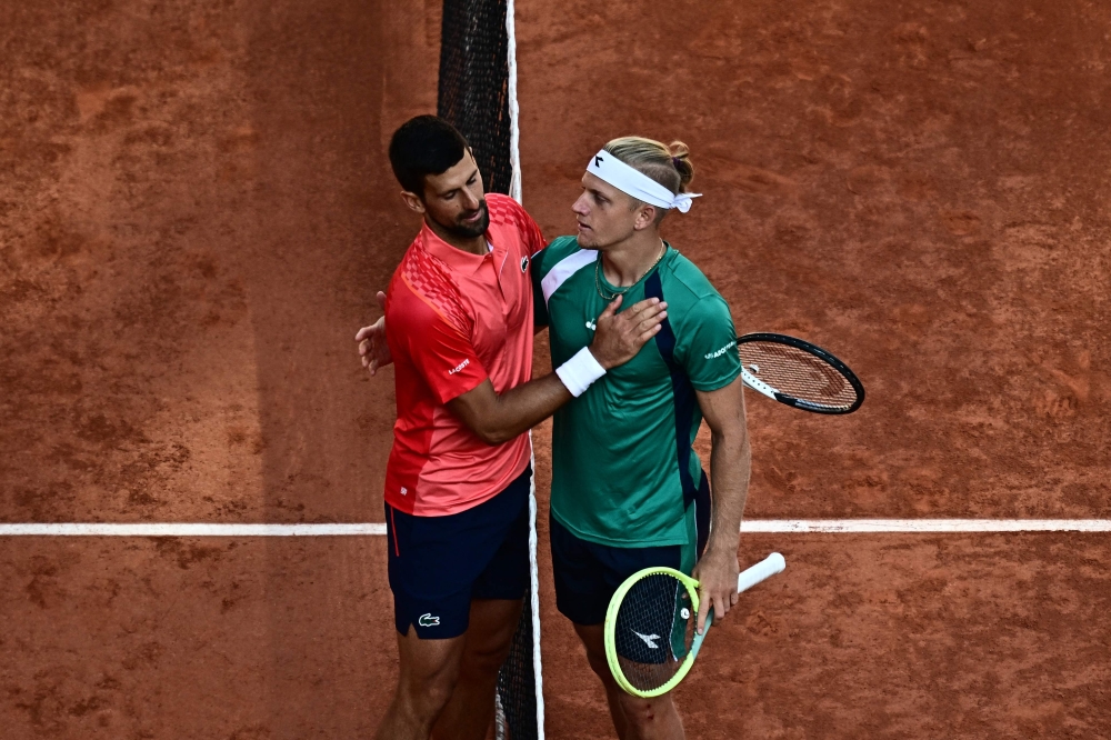 Serbia's Novak Djokovic greets Spain's Alejandro Davidovich Fokina after winning their men's singles match on day six of the Roland-Garros Open tennis tournament at the Court Philippe-Chatrier in Paris on June 2, 2023. (Photo by JULIEN DE ROSA / AFP)