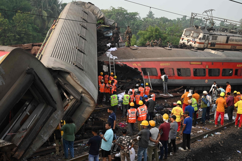 Rescue workers gather around damaged carriages at the accident site of a three-train collision near Balasore, about 200 km (125 miles) from the state capital Bhubaneswar in the eastern state of Odisha, on June 3, 2023. (Photo by Dibyangshu Sarkar / AFP)