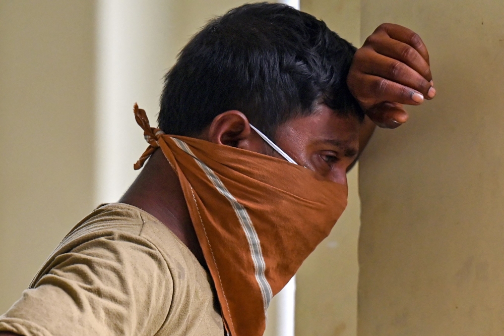 Graphic content / A victim's family member weeps at a business park used as temporary mortuary to identify the dead recovered from the carriage wreckage of a three-train collision near Balasore, in India's eastern state of Odisha, on June 4, 2023. (Photo by Punit PARANJPE / AFP)