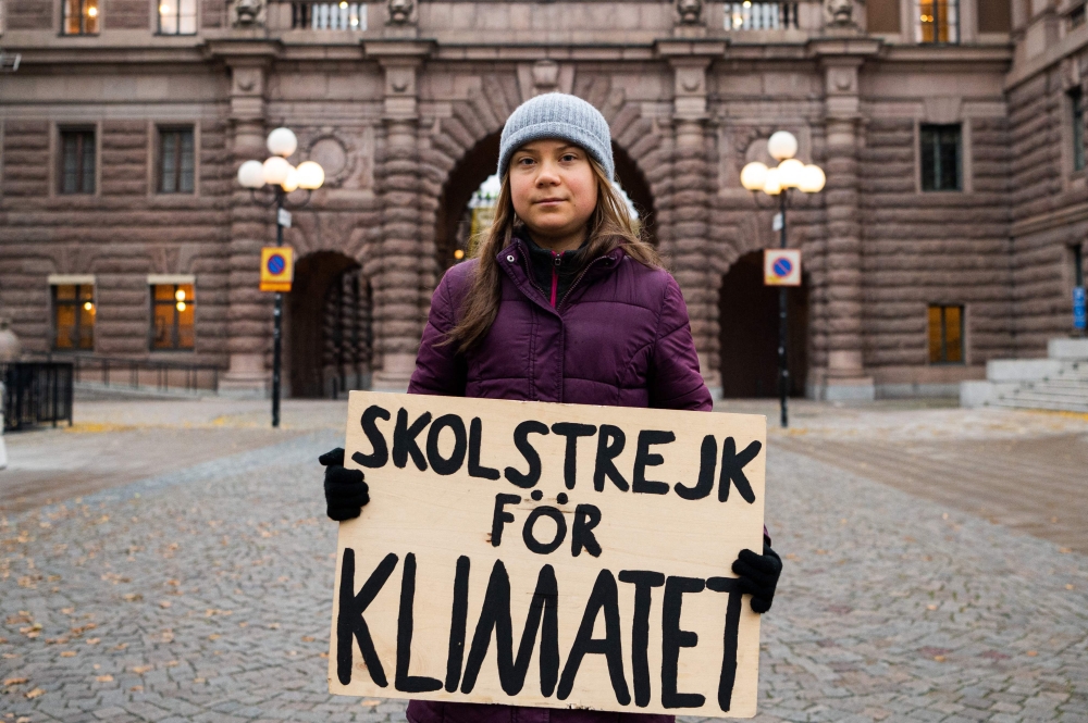 A file photo taken on November 19, 2021 shows Swedish climate activist Greta Thunberg as she poses for a picture holding a sign reading 