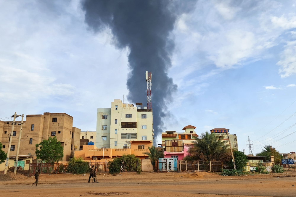 Black smoke billows behind buildings amid ongoing fighting in Khartoum on June 9, 2023. (Photo by AFP)