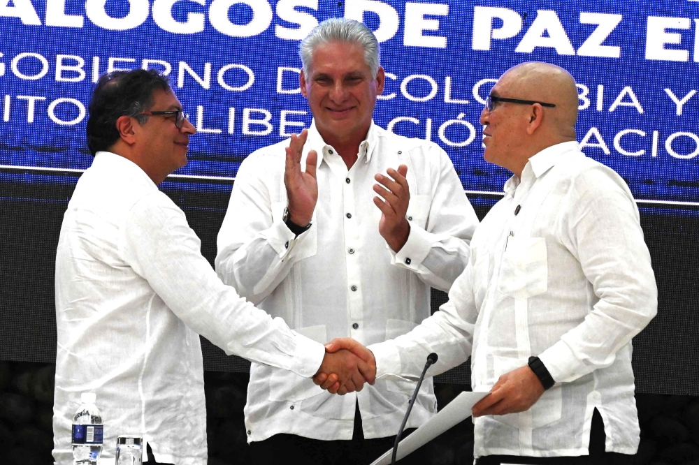 Colombian President Gustavo Petro (left) and ELN Guerrilla First Commander Antonio Garcia (right) shake hands next to Cuban President Miguel Diaz-Canel at the end of the closing of the Third Round of Peace Negotiation between the Colombian Government and the National Liberation Army (ELN) at El Laguito in Havana, on June 9, 2023. (Photo by Yamil Lage / AFP)