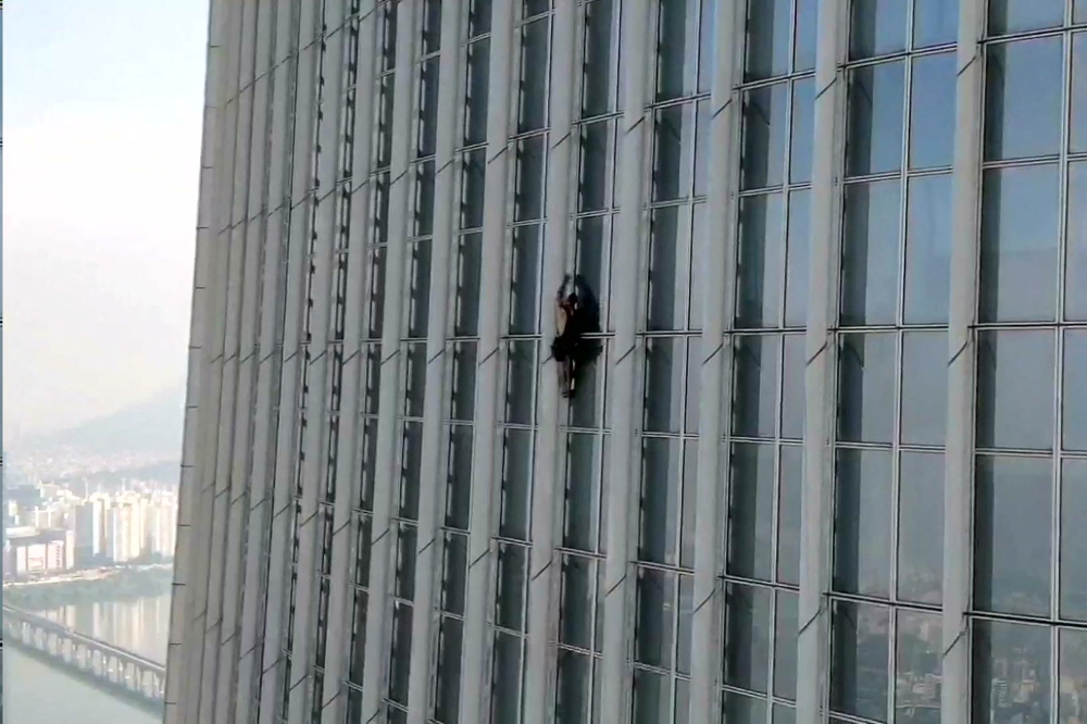 This handout photo taken on June 12, 2023 and provided by the Seoul Metropolitan Fire and Disaster Management Headquarters shows a man, identified by authorities as British, climbing the exterior of the 123-story Lotte World Tower in Seoul. (Photo by Handout / Seoul Metropolitan Fire and Disaster Management Headquarters / AFP) 