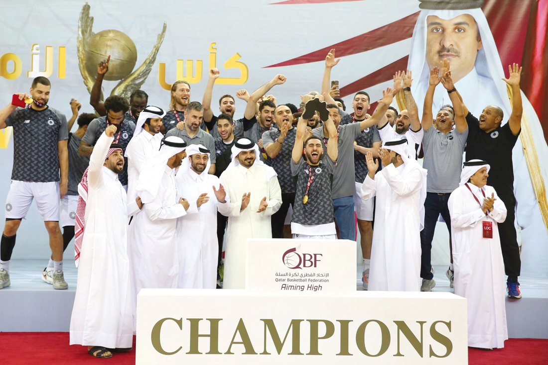 QOC President H E Sheikh Joaan bin Hamad Al Thani applauds as Al Sadd's players and officials celebrate after receiving the prestigious Amir Cup trophy following their win over Al Ahli in the final at Al Gharafa Sports Club yesterday.   