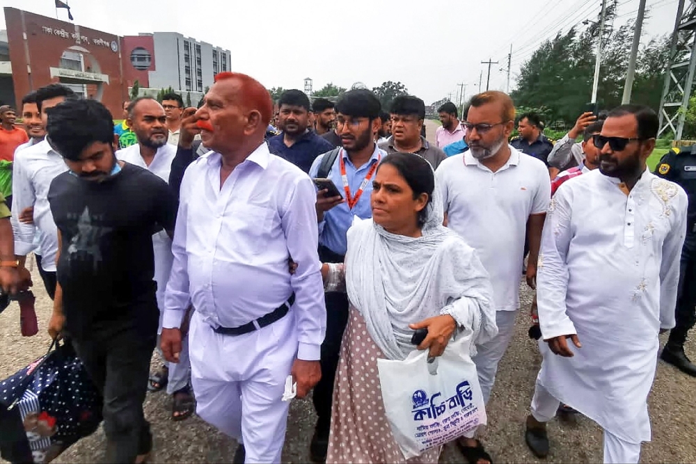 Shahjahan Bhuiyan (second left) walks out from jail after his release in Keraniganj on June 18, 2023. (Photo by AFP)