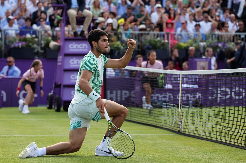 Spain's Carlos Alcaraz reacts after scoring a point against France's Arthur Rinderknech during their men's single tennis match on Day 4 of the Cinch ATP tennis Championships at Queen's Club in west London, on June 20, 2023. (Photo by Adrian DENNIS / AFP)
