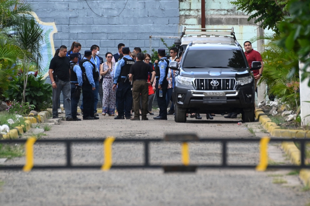 Prison staff, judges, and police officers remain inside the Women's Social Adaptation Center (CEFAS) prison after a fire following a brawl between inmates in Tamara, some 25 kilometers from Tegucigalpa, Honduras, on June 20, 2023.   (Photo by Orlando SIERRA / AFP)
