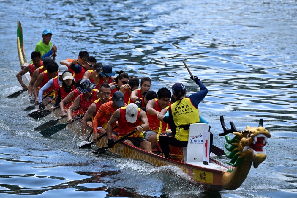 Competitors take part in dragon boat races held to celebrate the Tuen Ng festival in the Aberdeen typhoon shelter in Hong Kong on June 22, 2023. (Photo by Peter PARKS / AFP)
