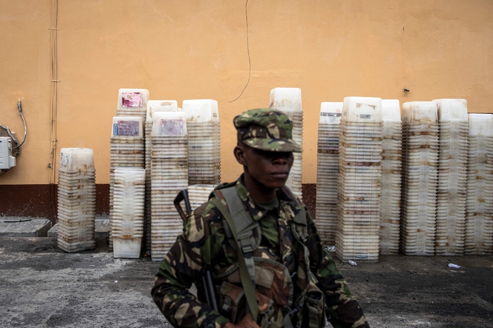 Soldier of the Sierra Leone Armed Forces walks past ballot boxes in Freetown on June 23, 2023. Photo by JOHN WESSELS / AFP