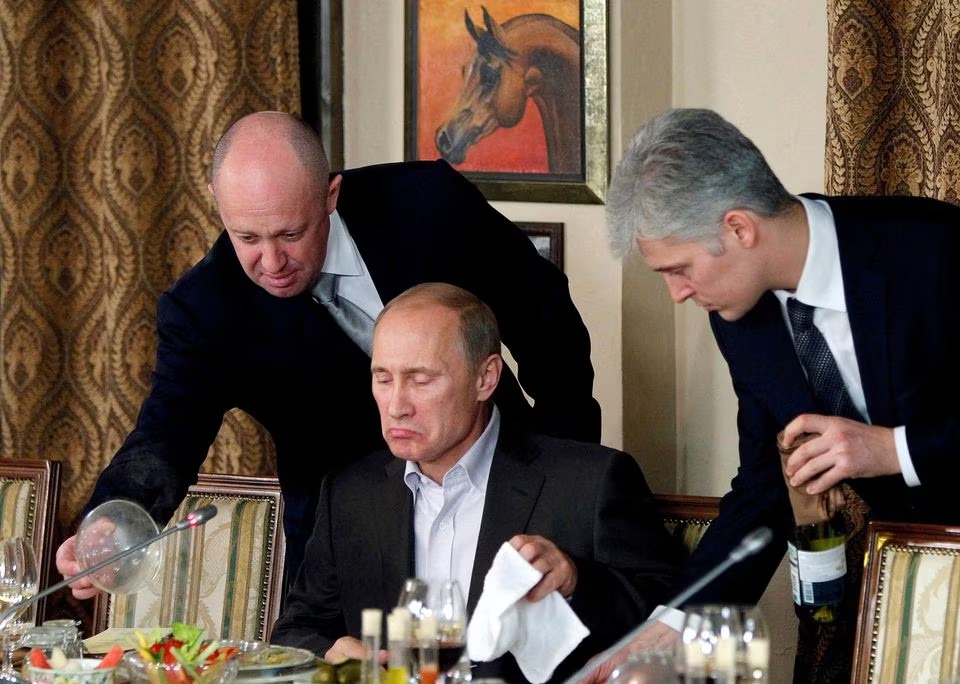 Yevgeny Prigozhin (L) assists Russian Prime Minister Vladimir Putin during a dinner with foreign scholars and journalists at the restaurant Cheval Blanc on the premises of an equestrian complex outside Moscow November 11, 2011. REUTERS/Misha Japaridze/File Photo

