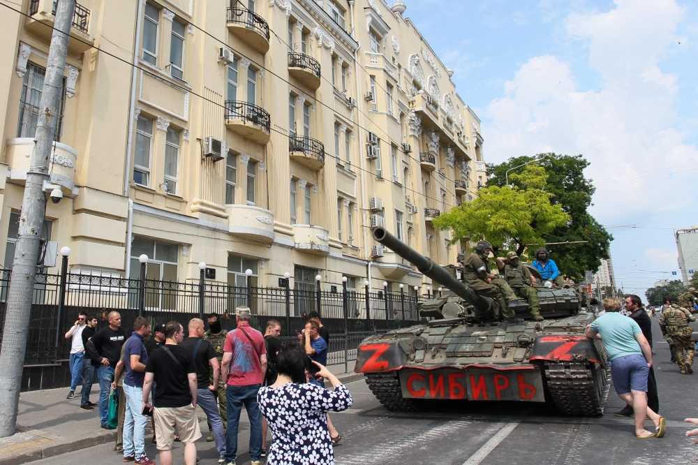 Members of Wagner group sit atop of a tank in a street in the city of Rostov-on-Don, on June 24, 2023. (Photo by STRINGER / AFP)