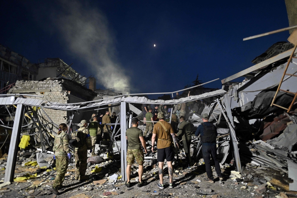 Rescuers and volunteers work to rescue people from under the rubble after Russian missile strike hit a restaurant and several houses in Kramatorsk, eastern Ukraine, on June 27, 2023. (Photo by Genya SAVILOV / AFP)