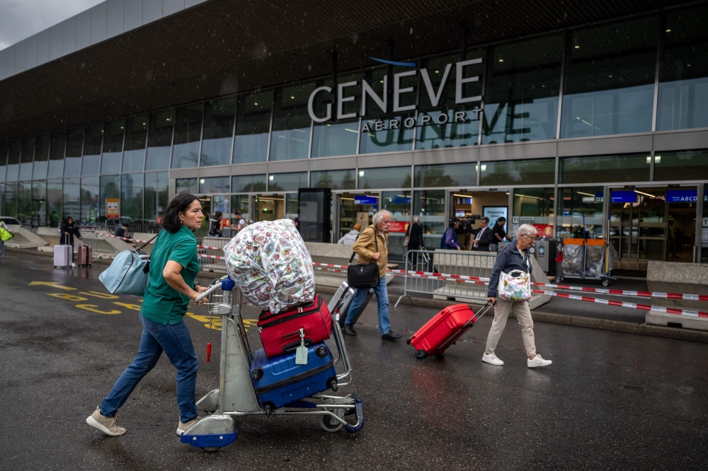 Travellers arrives at Geneva's international airport during strikes on June 30, 2023. Flights at Geneva's international airport will be grounded for four hours due to a workers' strike, affecting thousands of passengers at the start of summer travel season. (Photo by Fabrice COFFRINI / AFP)
