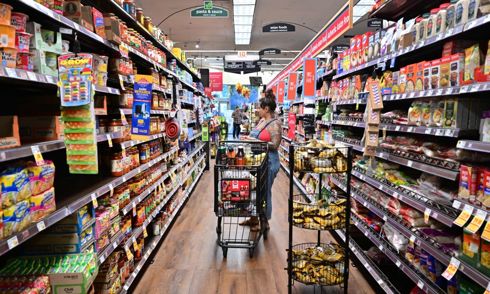 :(FILES) A woman shops for groceries at a supermarket in Monterey Park, California on October 19, 2022. The US inflation measure most closely watched by the Federal Reserve declined sharply in May, official figures showed June 30, 2029, returning to a downward trend after a jump a month earlier. Much of the slowdown was due to a sharp drop in energy prices, and food prices to a lesser extent. (Photo by Frederic J. BROWN / AFP)
