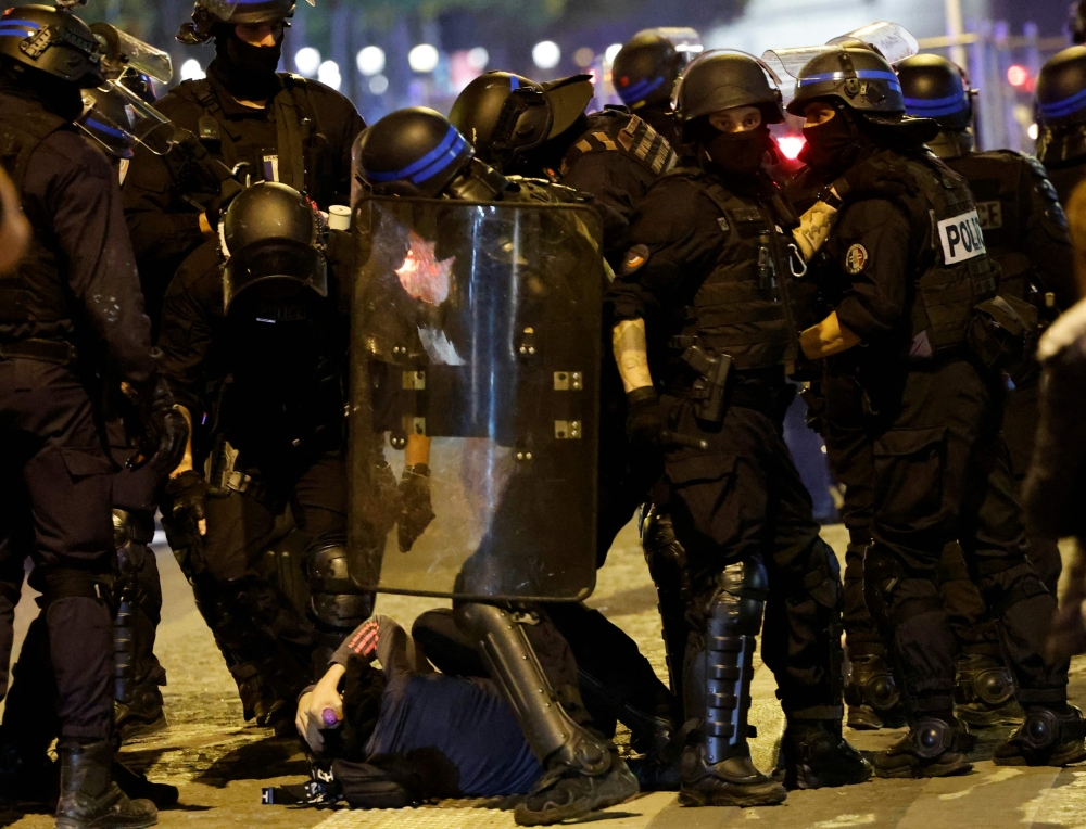 French police officers detain a demonstrator in Paris on July 2, 2023, five days after a 17-year-old man was killed by police in Nanterre, a western suburb of Paris. (Photo by Ludovic Marin / AFP)